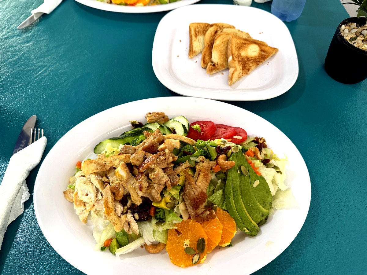 Ensalada fresca con pollo a la plancha, aguacate, naranja y semillas — Restaurante Tita, Playa Azul